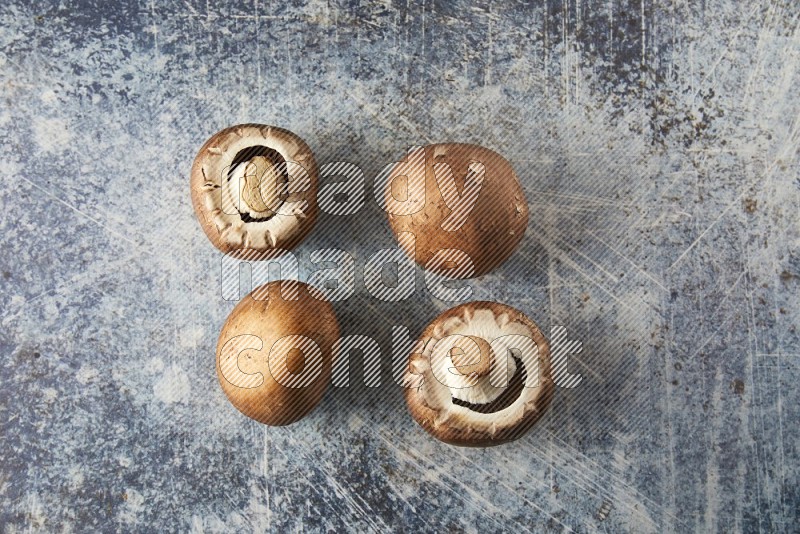 small fresh Cremini wood mushrooms topview on blue textured background