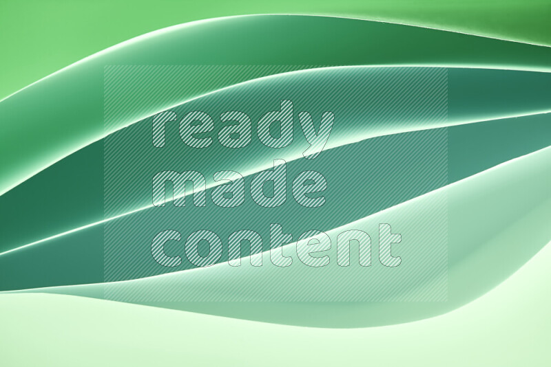 This image showcases an abstract paper art composition with paper curves in green gradients created by colored light