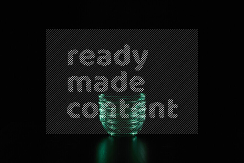 Glassware with rim light in green against black background