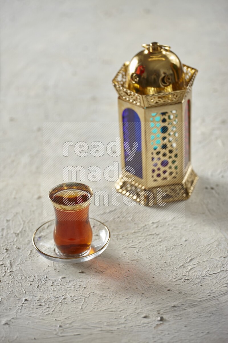 A golden lantern with different drinks, dates, nuts, prayer beads and quran on textured white background