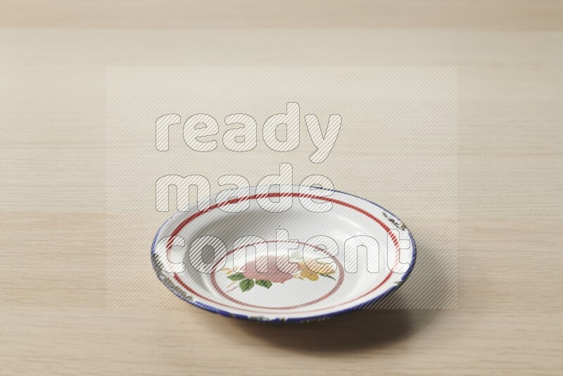 صحن معدني عتيق على خلفية خشبية فاتحة