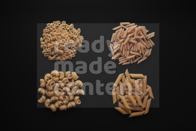 Different pasta types in bunches on black background