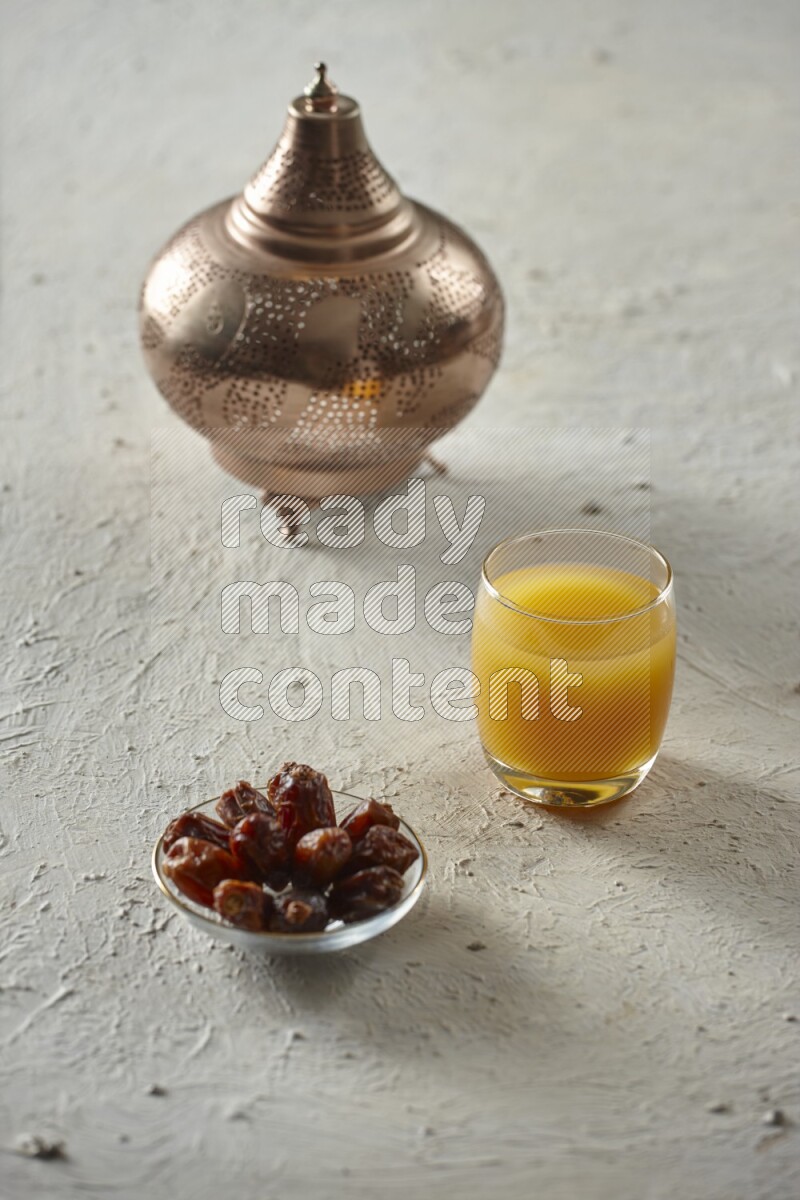 A golden lantern with different drinks, dates, nuts, prayer beads and quran on textured white background