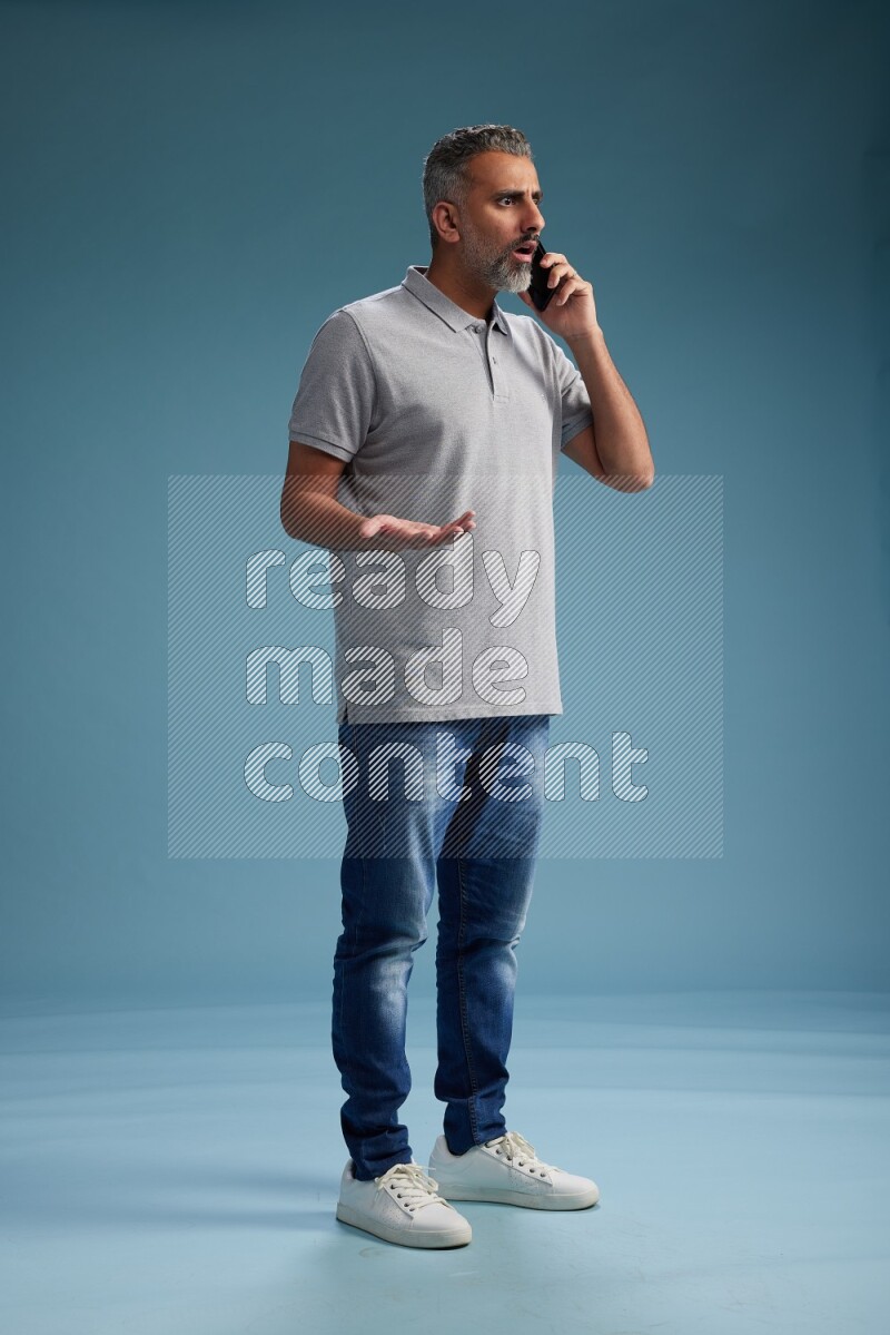 Man Standing talking on phone on blue background