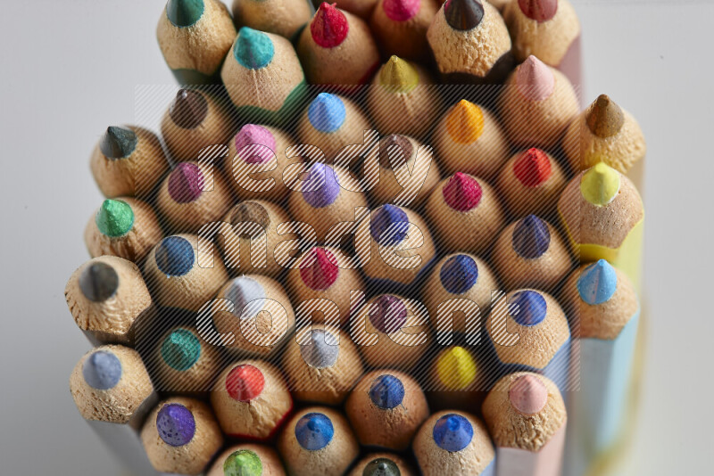 The image captures top view shot of sharpened colored pencils on grey background