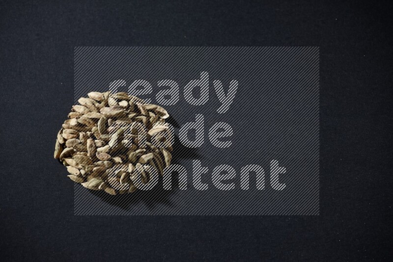 حبوب الهيل في شكل دائري على خلفية سوداء