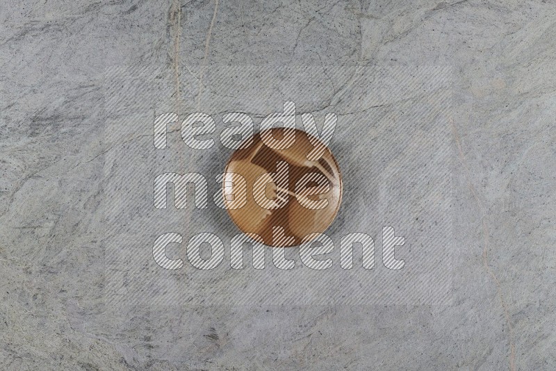 Top View Shot Of A Multicolored Pottery Plate On Grey Marble Flooring