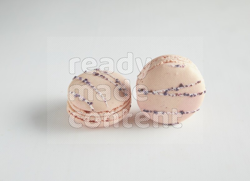 45º Shot of two pink orange blossom macarons on white background