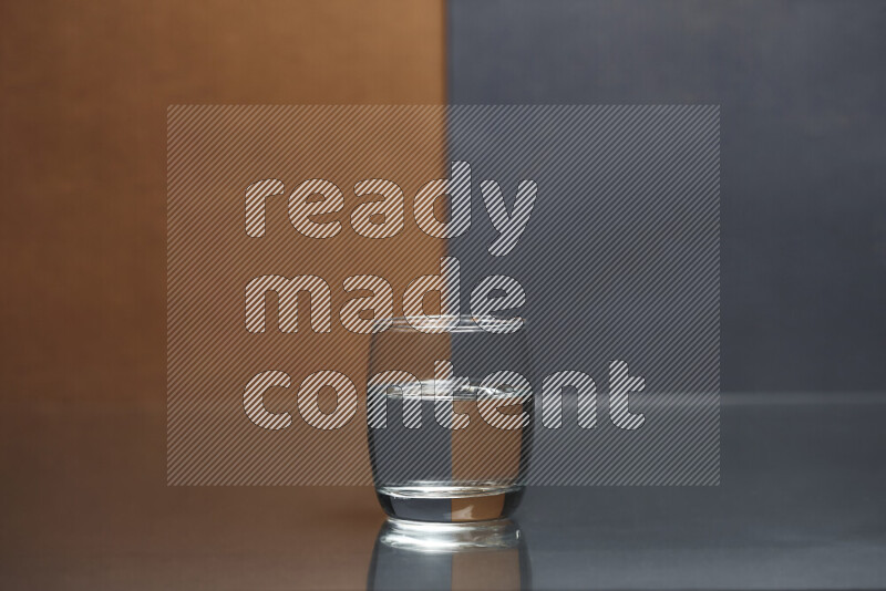 The image features a clear glassware filled with water, set against brown and dark blue background