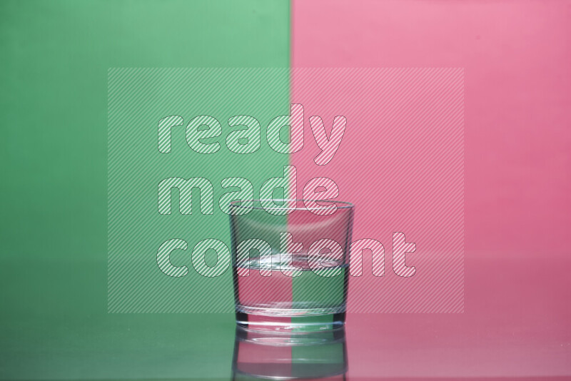 The image features a clear glassware filled with water, set against green and pink background