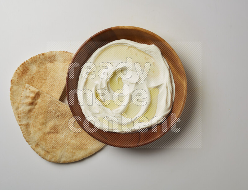 Lebnah garnished with olive oil in a wooden plate on a white background