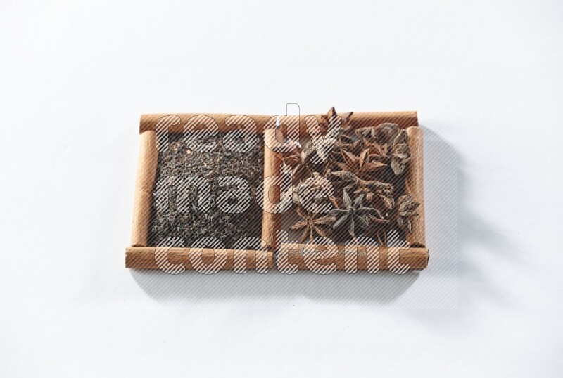 2 squares of cinnamon sticks full of black tea and star anise on white flooring