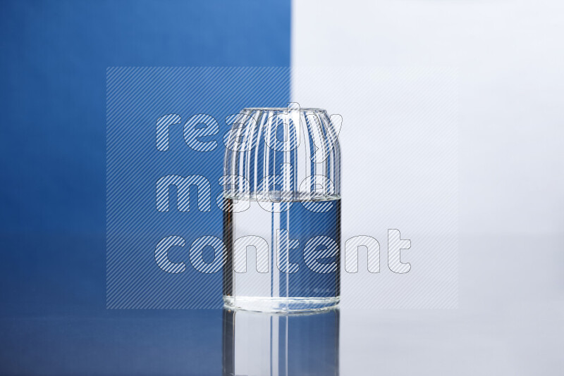 The image features a clear glassware filled with water, set against white and blue background