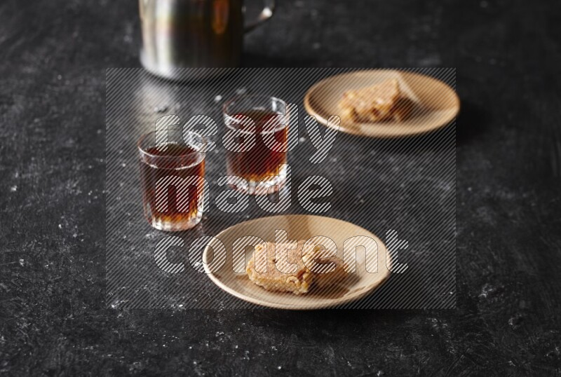 بسبوسة مع الشاي علي خلفية سوداء خشبية