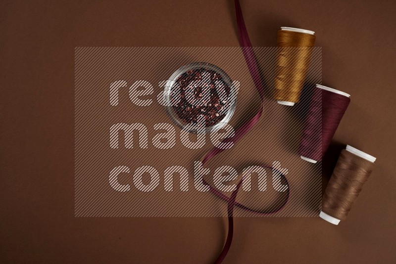 Red sewing supplies on brown background