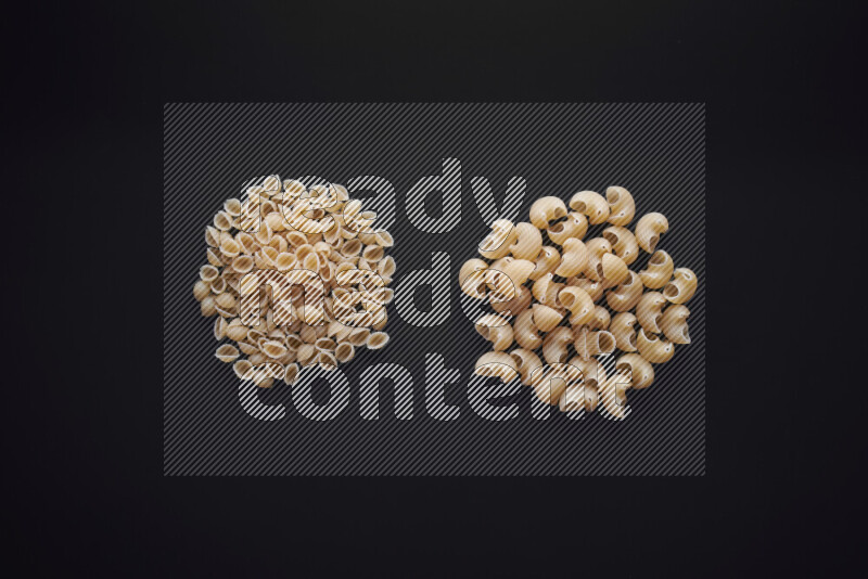 Different pasta types in bunches on black background