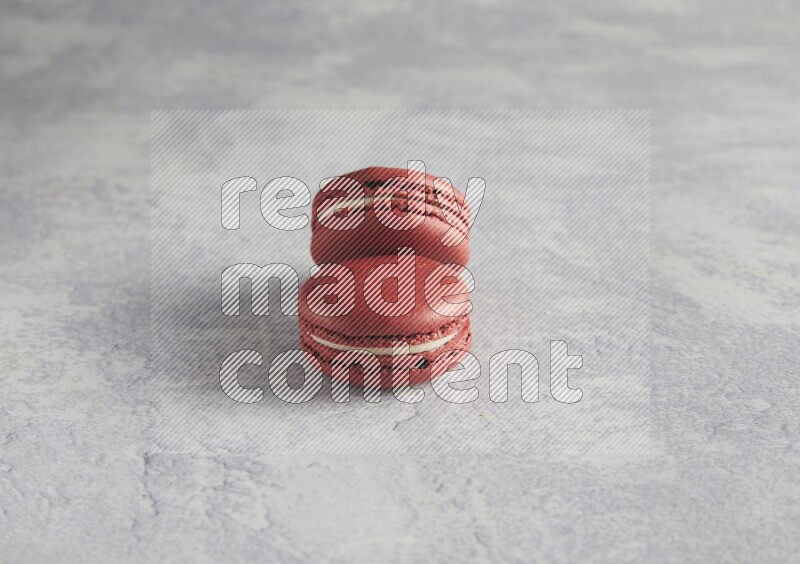 45º Shot of two Red Velvet macarons  on white  marble background