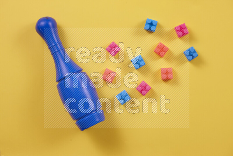 Plastic building blocks, balls and bowling pins on different colored backgrounds (kids toys)