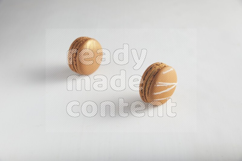 45º Shot of of two assorted Brown Irish Cream, and Brown Coffee macarons  on white background