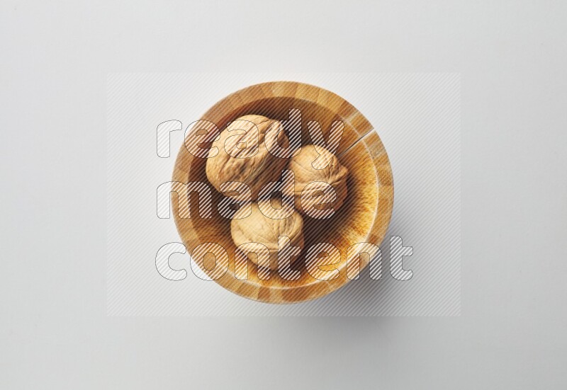 Top-view shot of walnut in a container on white background