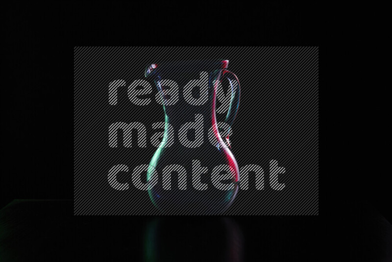 Glassware with rim light in red and green against black background