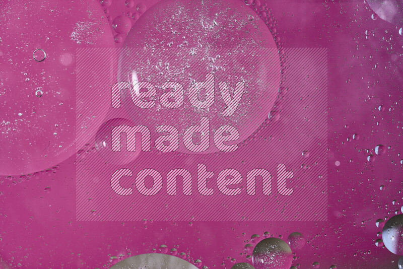 لقطات مقربة لفقاعات من الزيت على سطح الماء باللون الوردي