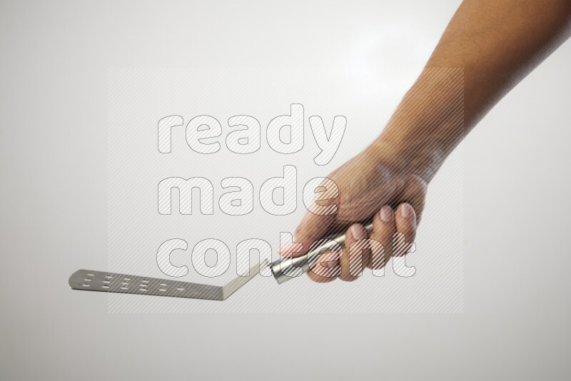Male Hand Holding Burger Flipper on white background