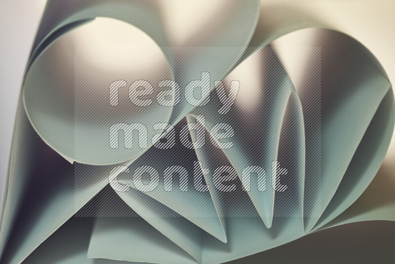 عرض فني لطيات الورق تخلق مزيج من الأشكال الهندسية، مضاءة بإضاءة ناعمة بدرجات اللون الأخضر والالوان الدافئة