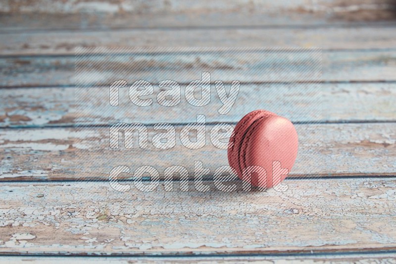 45º Shot of Pink Raspberry macaron on light blue wooden background