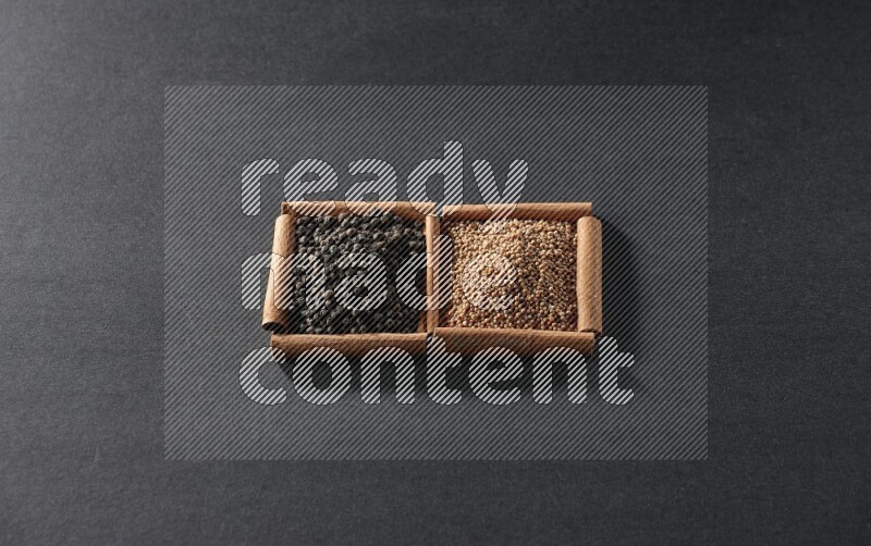 2 squares of cinnamon sticks full of mustard seeds and black peppers on black flooring