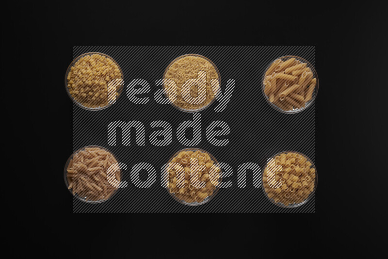 أنواع مختلفة من المعكرونة في أوعية زجاجية علي خلفية سوداء