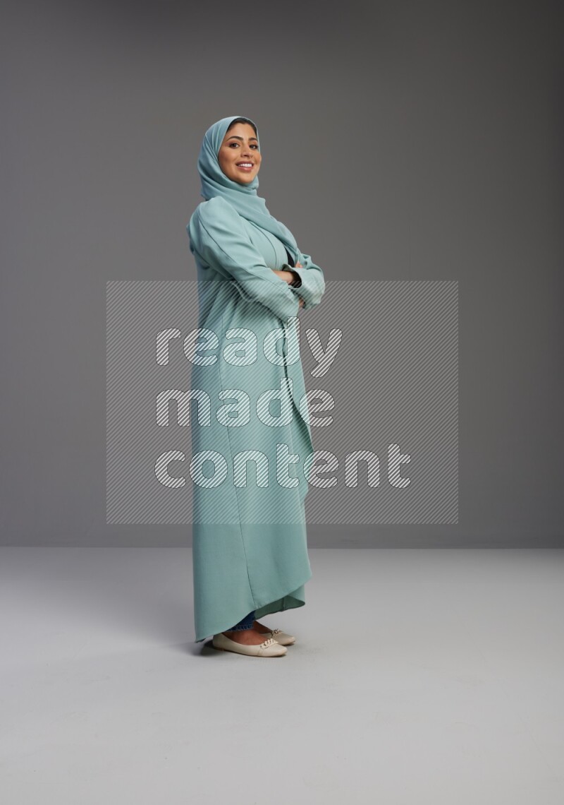 Saudi Woman wearing Abaya standing with crossed arms on Gray background