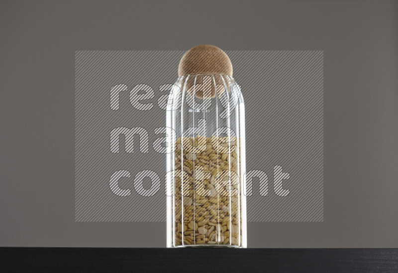 Crushed beans in a glass jar on black background