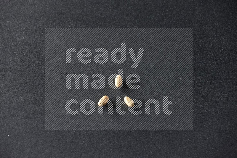 3 peeled peanuts on a black background in different angles