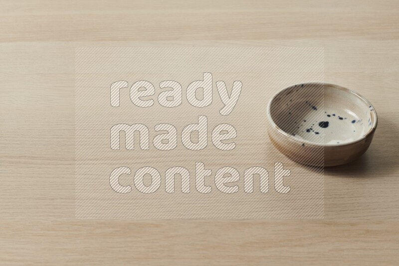 صحن فخاري متعدد الألوان على خلفية خشبية فاتحة