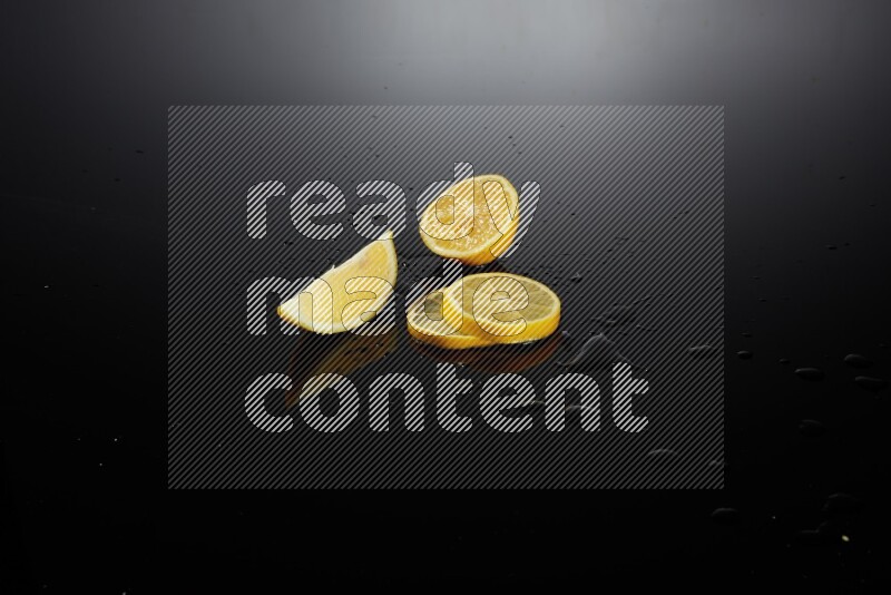Lemon slices with water drops, and droplets on black background