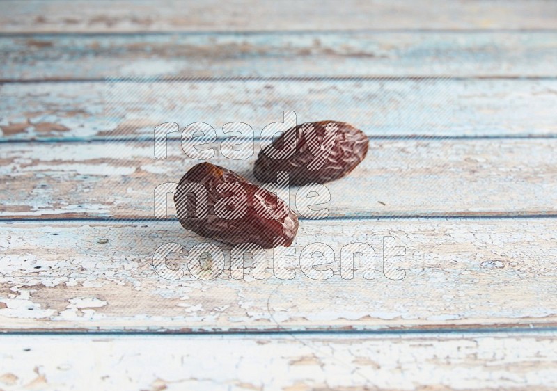 two madjoul dates on a light blue wooden background