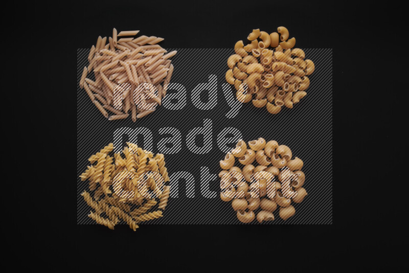 Different pasta types in bunches on black background