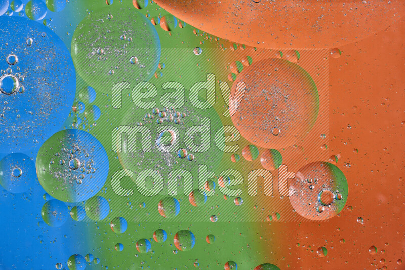 لقطات مقربة لفقاعات من الزيت على سطح الماء باللون البرتقالي والأخضر والأزرق