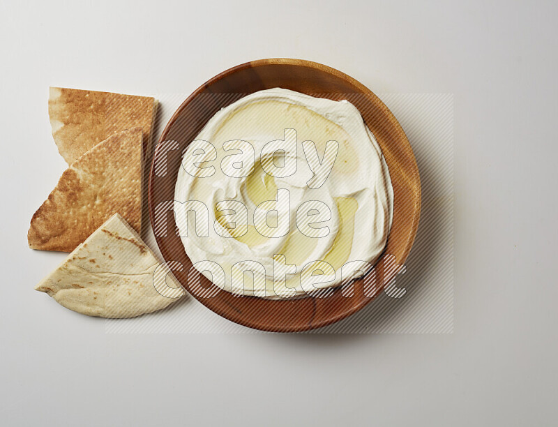 Lebnah garnished with olive oil in a wooden plate on a white background