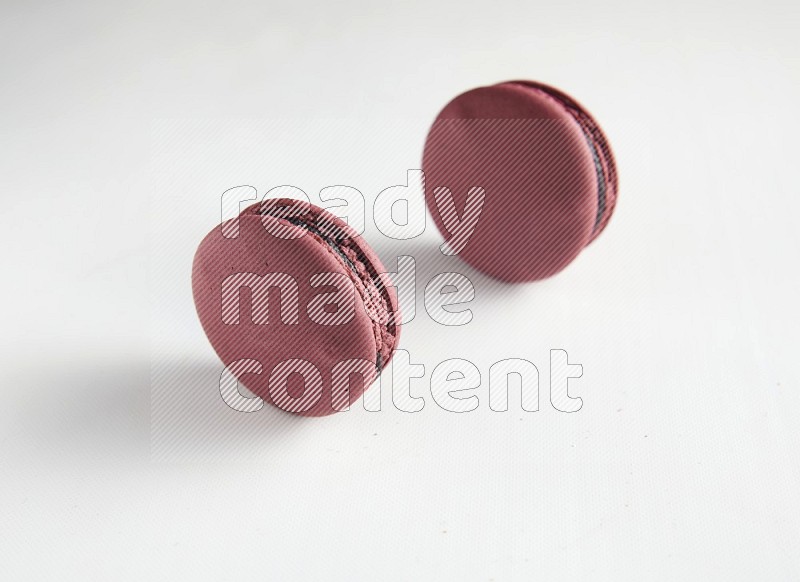 45º Shot of two Red Cherry macarons on white background