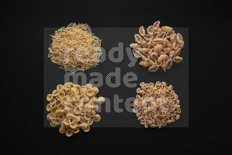 Different pasta types in bunches on black background