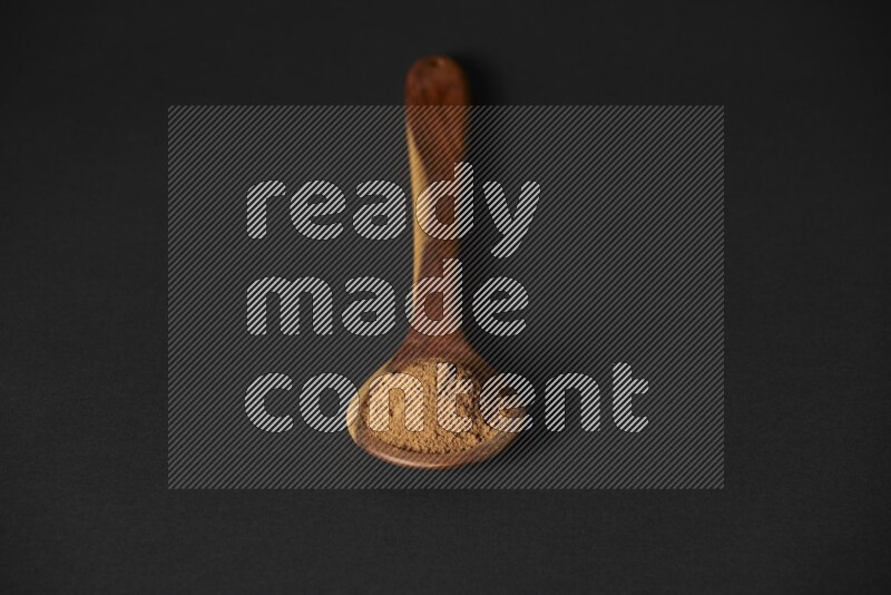 بودرة القرفة في مغرفة خشبية