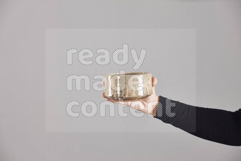 A woman in black abaya holding different pottery essentials in different positions