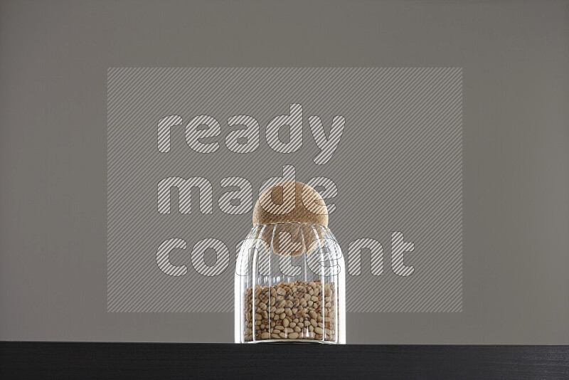 Black-eyed peas in a glass jar on black background