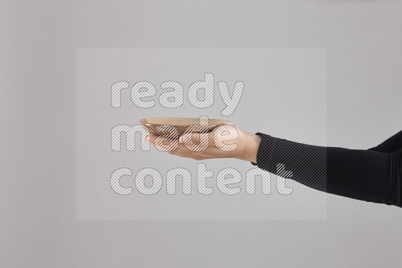 A woman in black abaya holding different pottery essentials in different positions