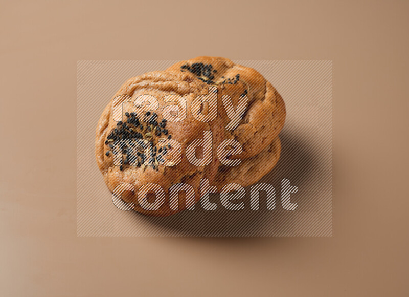 Hasawi cookies field with date and decorated by black seed and Anise grain on a brown background
