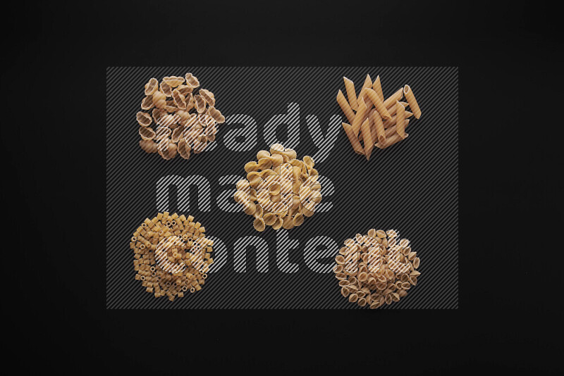 Different pasta types in bunches on black background