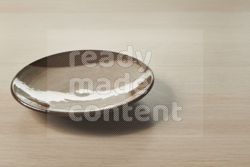A multicolored pottery plate on light wooden background