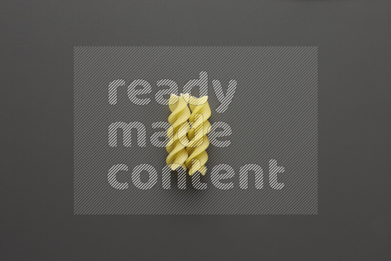 Fusilli pasta on grey background